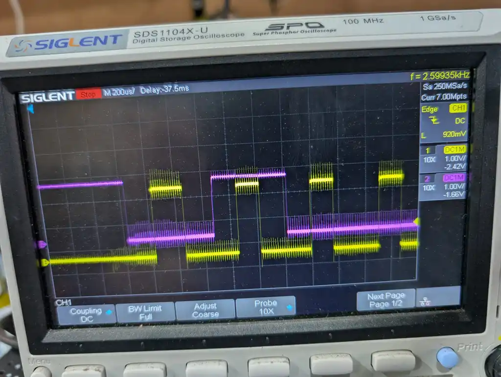 The same oscilloscope showing a second capture of the eMMC initialisation exchange, the yellow and magenta traces running further bursts of fast pulses between idle levels.
