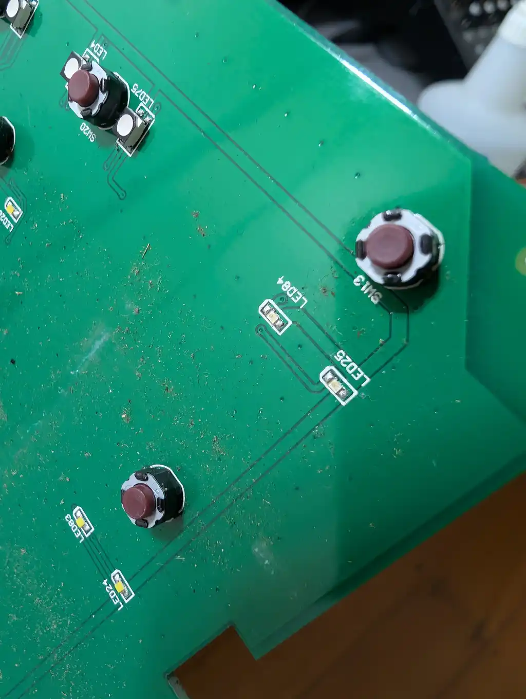 The underside of the DJ controller's performance pad board, with its tactile switches and the LED positions between them visible.