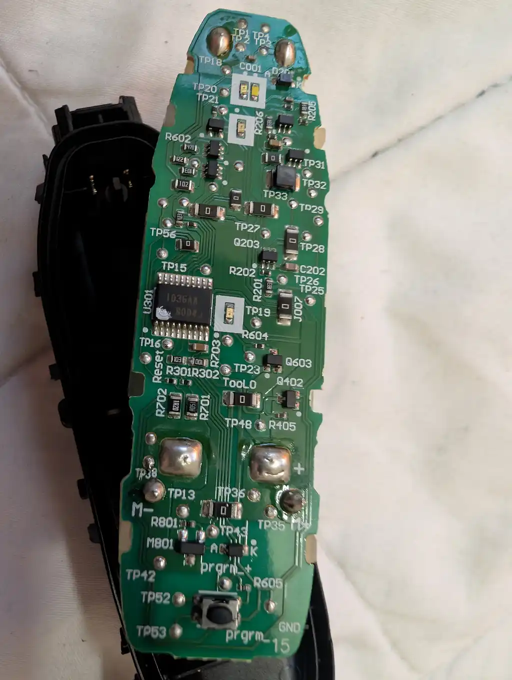 The Philips electric shaver's main circuit board, with its motor terminals, programming pads and test points exposed.