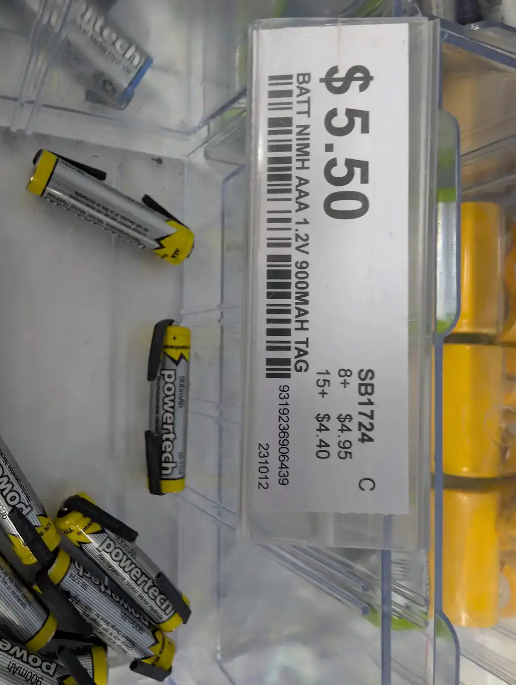 The replacement tagged NiMH cells in a bin at a local electronics shop, the shelf label showing $5.50 each, bought to rebuild the Philips electric shaver's battery.