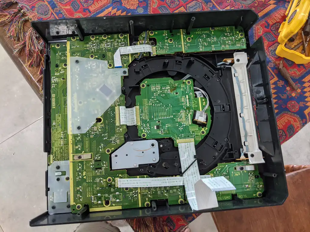 The Pioneer DVJ-1000 opened out on the bench, showing the mainboard, the disc transport mechanism and the ribbon cables linking them.